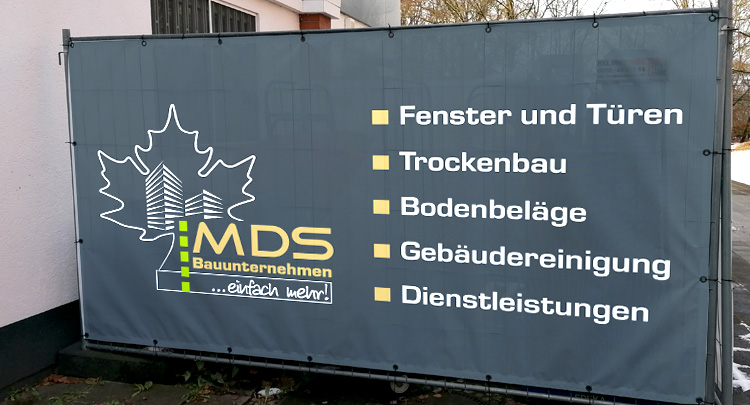 Werbebanner in Nürnberg an Bauzaun mit Logo und Leistungen einer Baufirma
